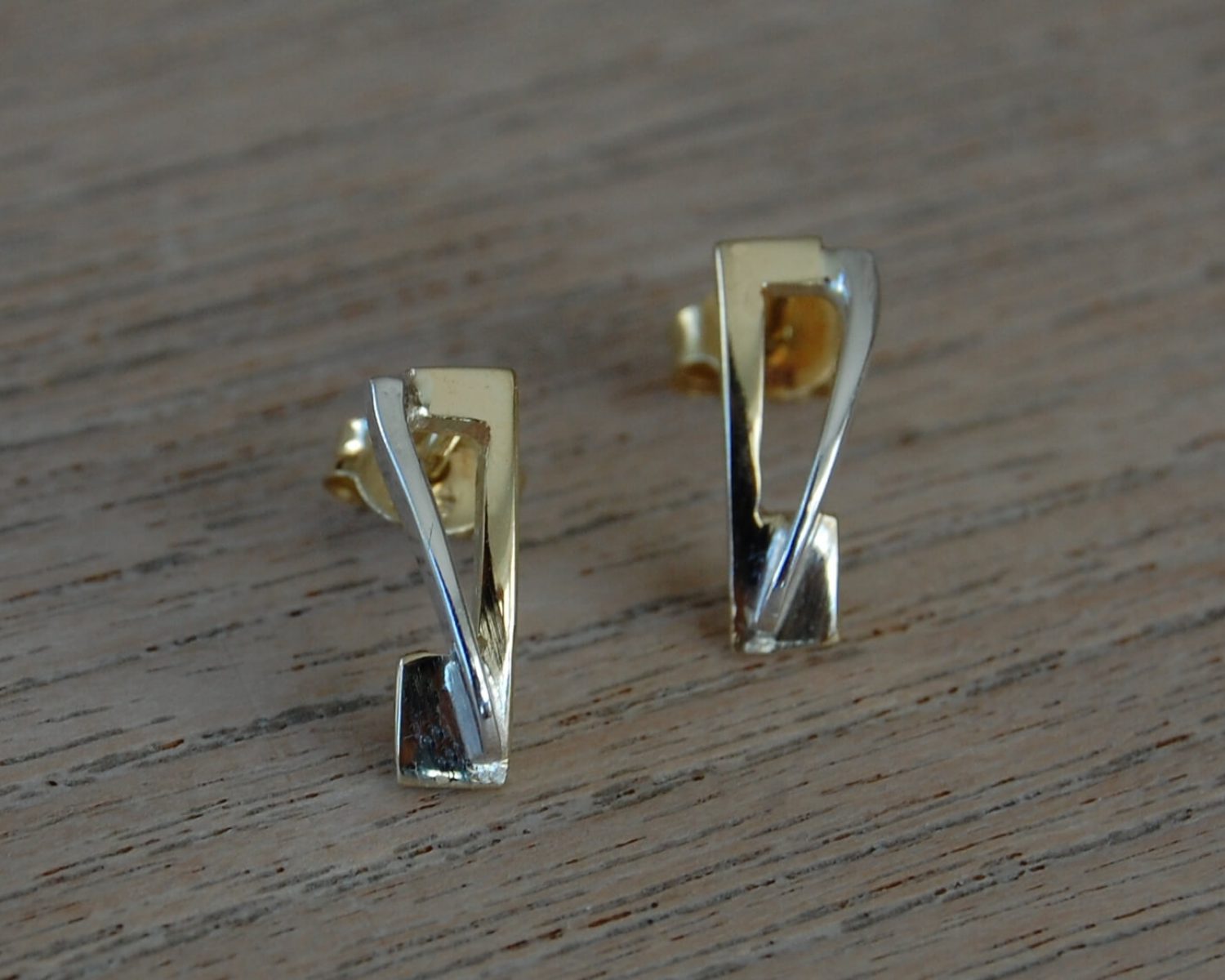 Oorbellen gemaakt uit aangeleverd goud met een accent in zilver, passend bij een herinneringshanger.