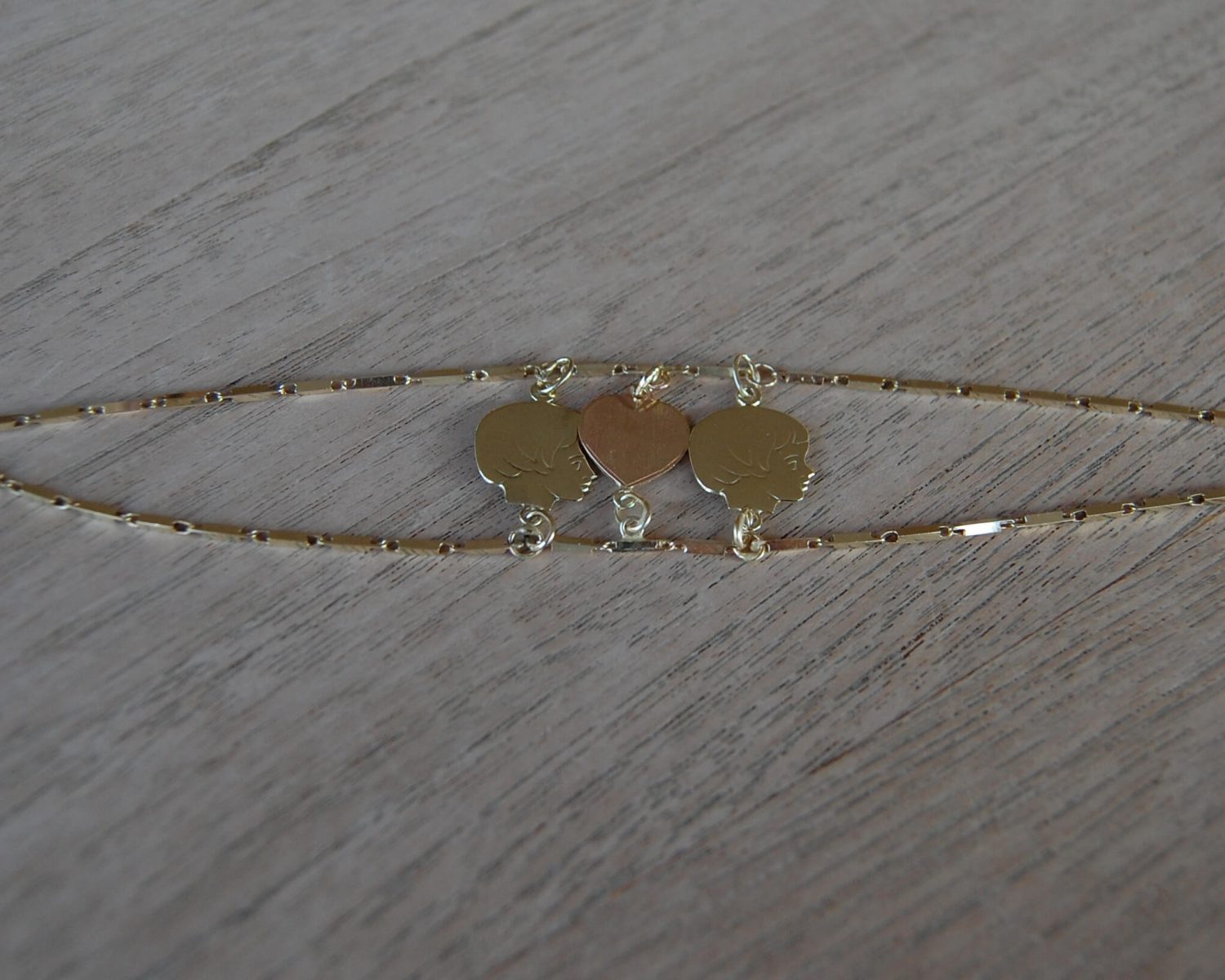 Van een aangeleverd gouden collier is een armband gemaakt - inclusief het verwerken van aangeleverde bedeltjes.