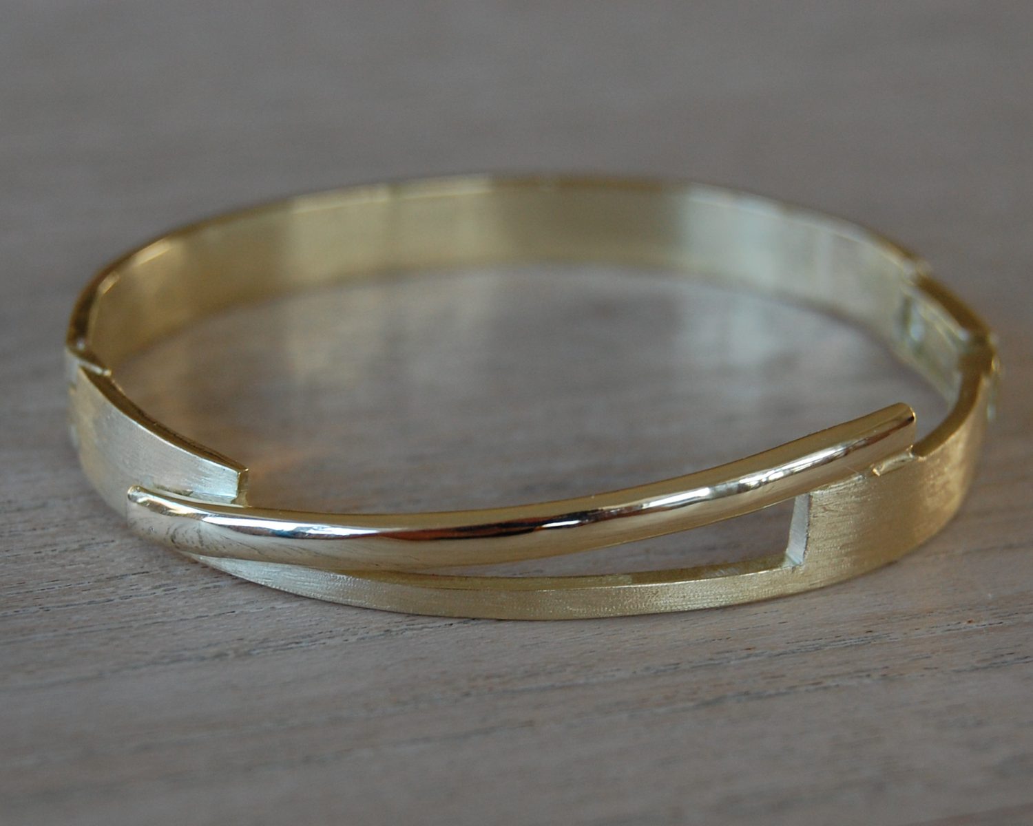 Ring gemaakt uit aangeleverd goud. Het accent wordt gevormd door een wat vlakker geslagen trouwring, waarbij de gravure leesbaar gebleven is. Hierbij zijn ook bijpassende oorbellen gemaakt.