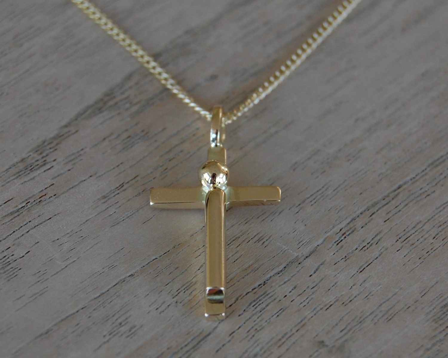 Hanger gemaakt uit het goud van aangeleverde trouwringen - aan de achterzijde is een bakje gevuld met wat as.
