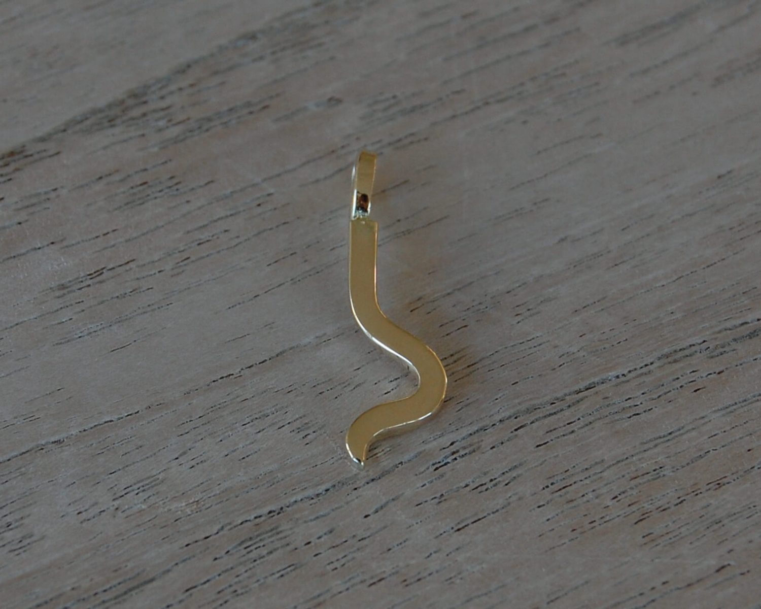 Symbolische hanger gemaakt uit het goud van aangeleverde trouwringen - aan de achterzijde is een bakje gevuld met wat as.