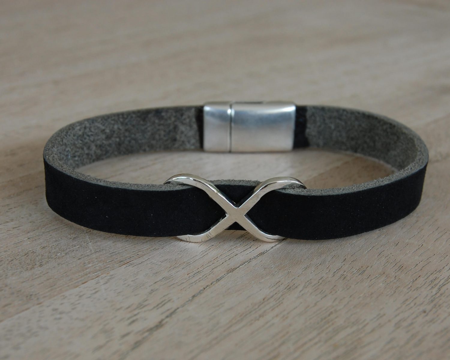 Leren herenarmband met symbool in zilver, gevuld met wat as.