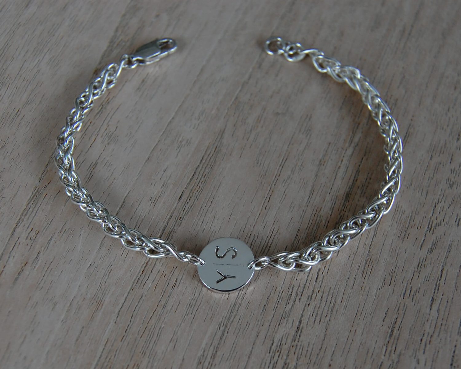 Armband in zilver, inclusief uitgezaagde voorletters van de twee dochters.