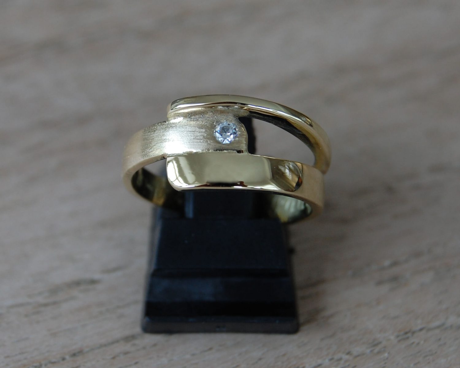 Ring gemaakt uit aangeleverde trouwringen - inclusief zirkonia. Aan de binnenzijde van de ring is een bakje gemaakt, gevuld met wat as.
