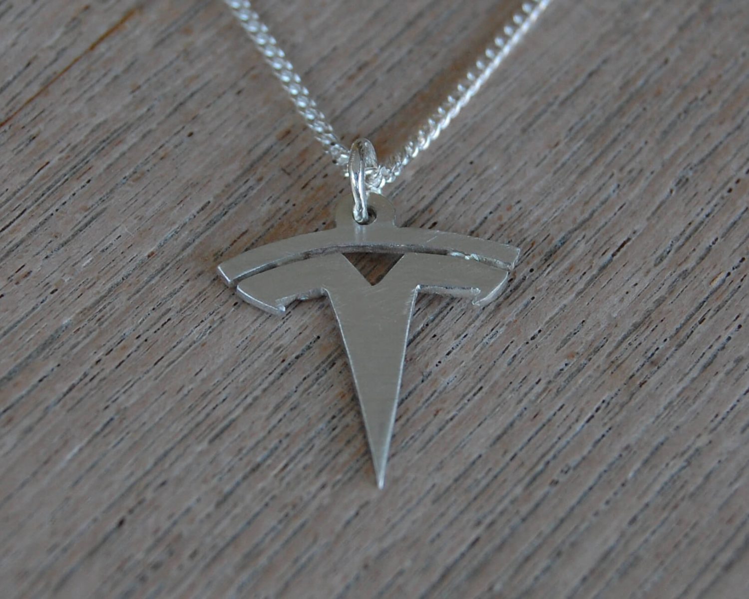 Hanger van een logo inclusief collier in zilver.