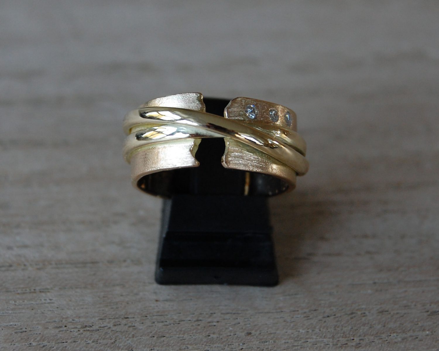 Symbolische ring uit aangeleverde 18 en 14 karaats gouden sieraden - inclusief 3 diamanten van 0,02 karaat. In de binnenzijde van de ring is wat as gezet.