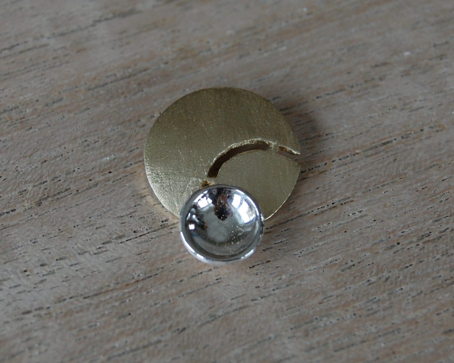Hanger met een basis uit aangeleverd goud en een accent in zilver.