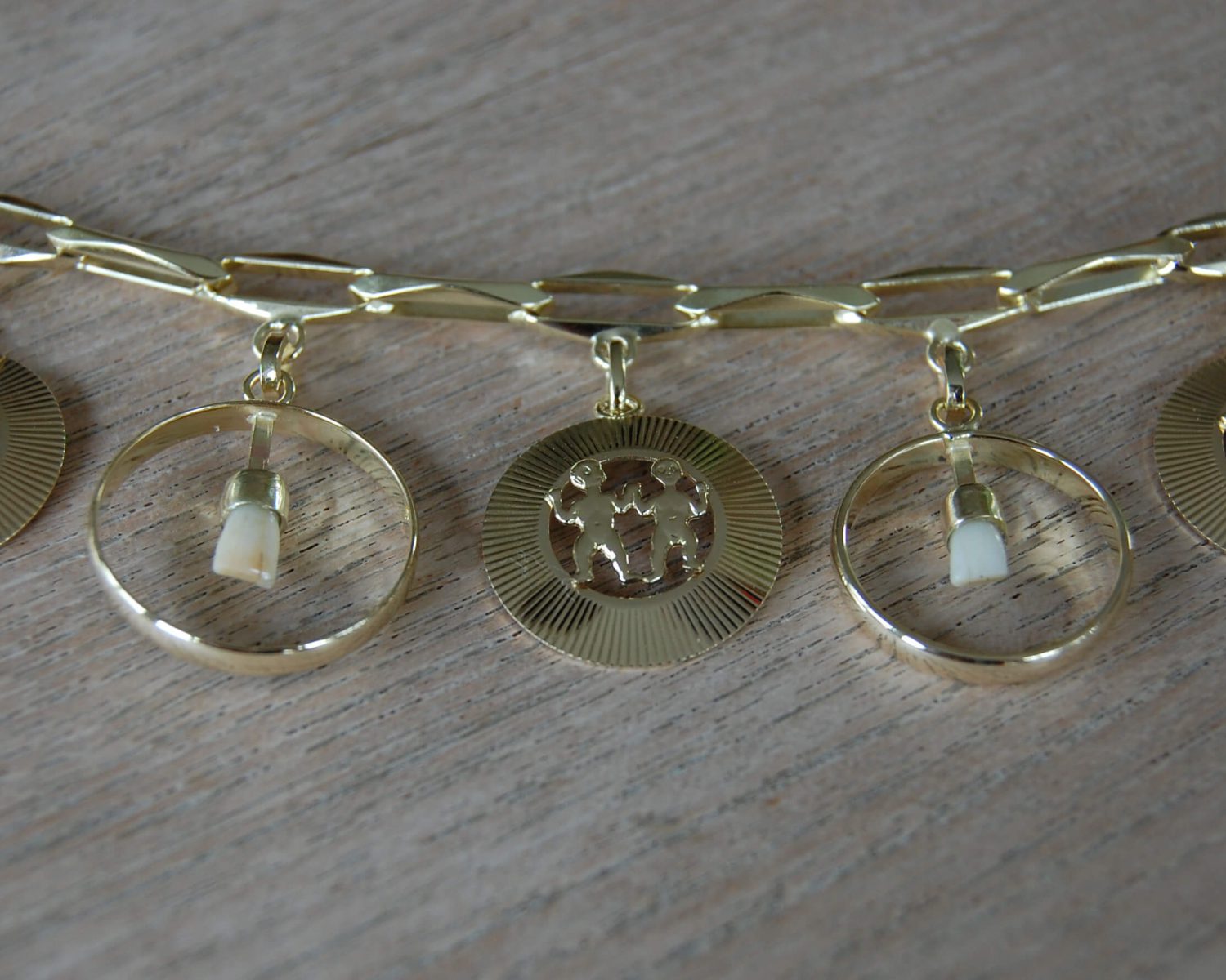 Aan een bestaande armband zijn 2 nieuwe bedels gemaakt, bestaande uit een trouwring met een tandje.