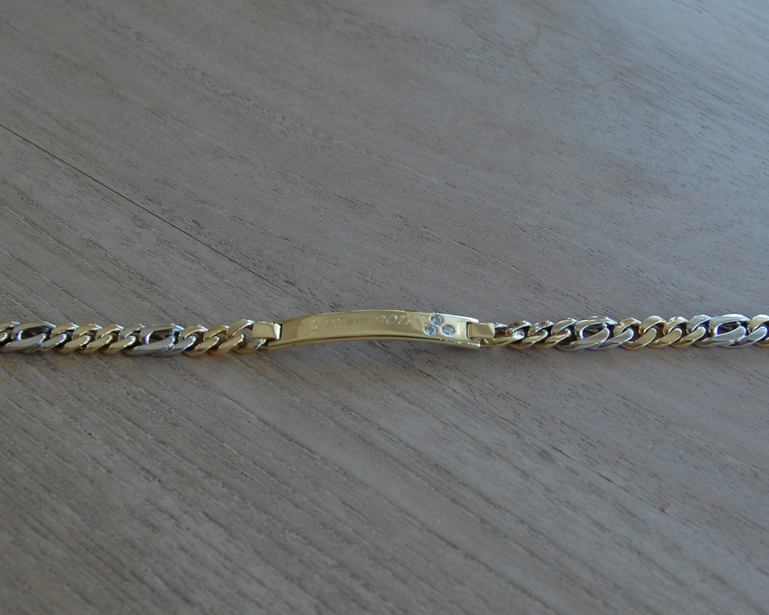 Herenarmband in 14 karaats geel- en witgoud - inclusief symbolische gravure en 3 opnieuw gezette zirkonia's.