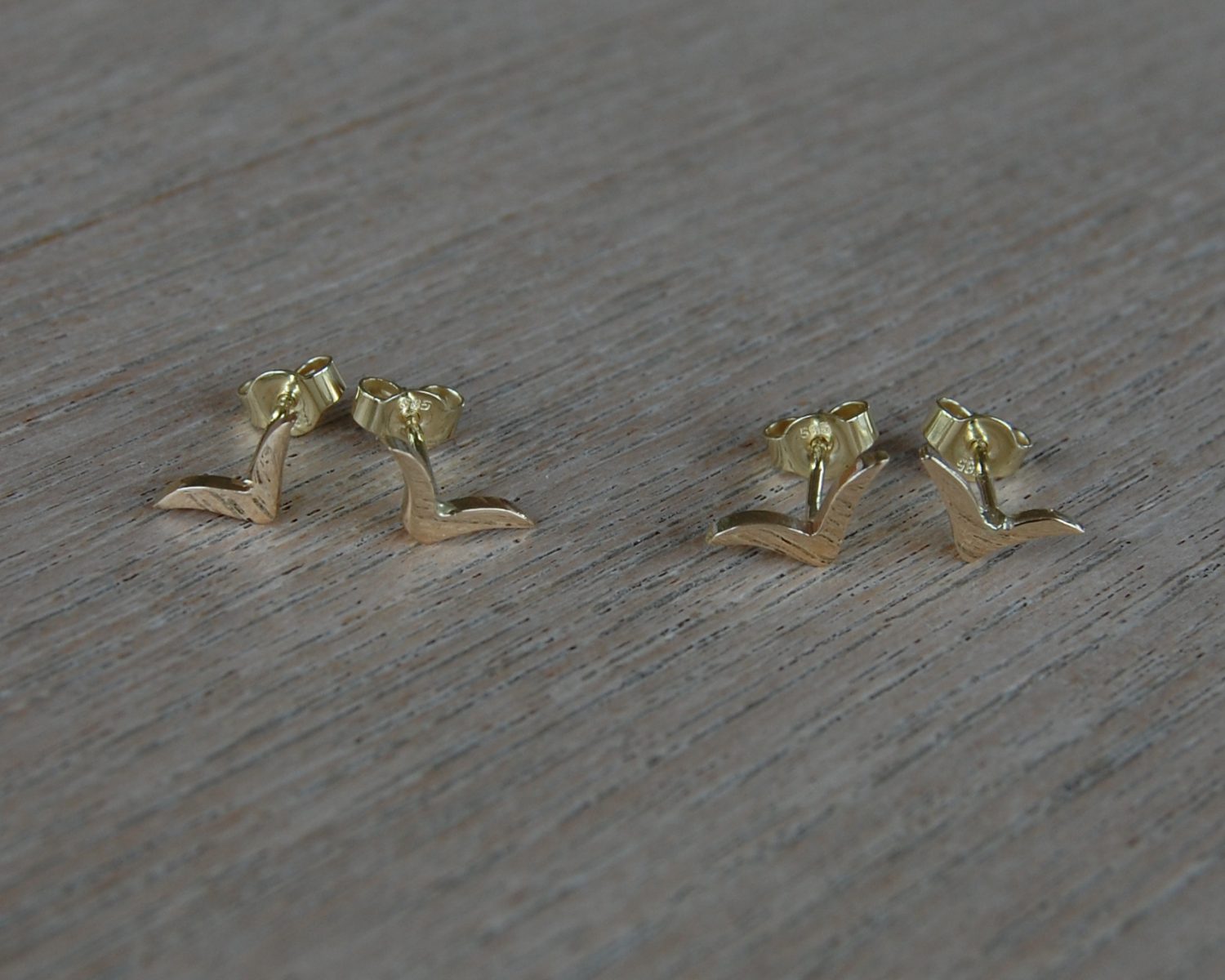 Symbolische oorbellen gemaakt uit aangeleverde gouden sieraden.