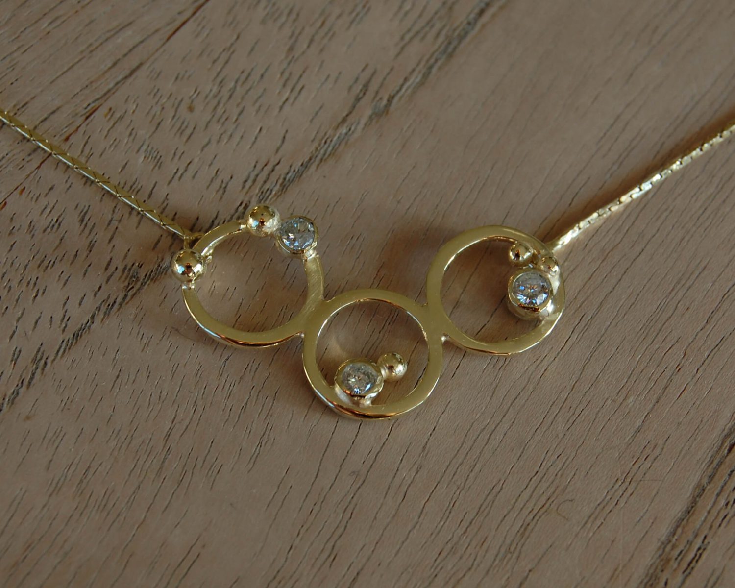 Collier met symbolische accenten uit aangeleverd goud - inclusief 3 opnieuw gezette diamanten.